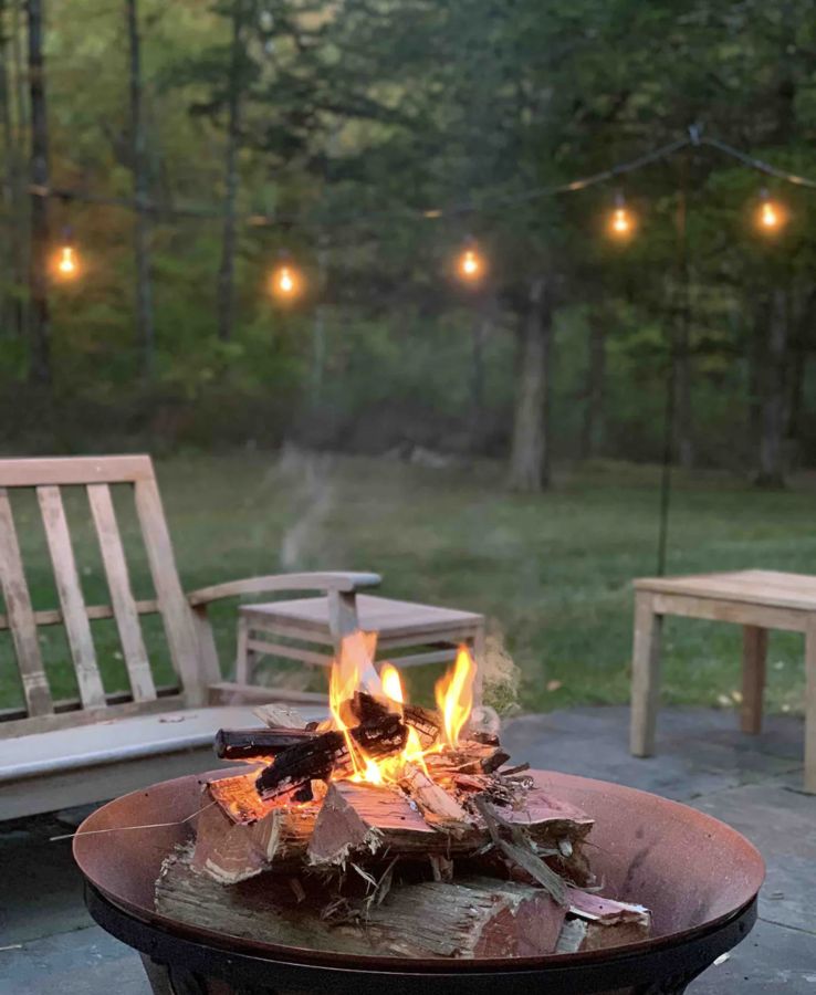 Solo Stove fire burning under string lights at dusk