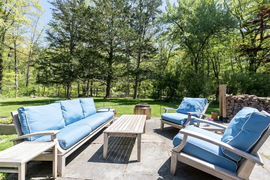 Patio with blue-cushioned teak sofa and chairs