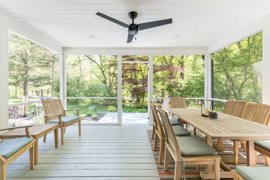Screened porch with teak dining set and lounge chairs